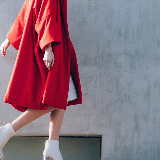 donna-elegante-indossa-un-cappotto-rosso-di-seconda-mano-e-cammina